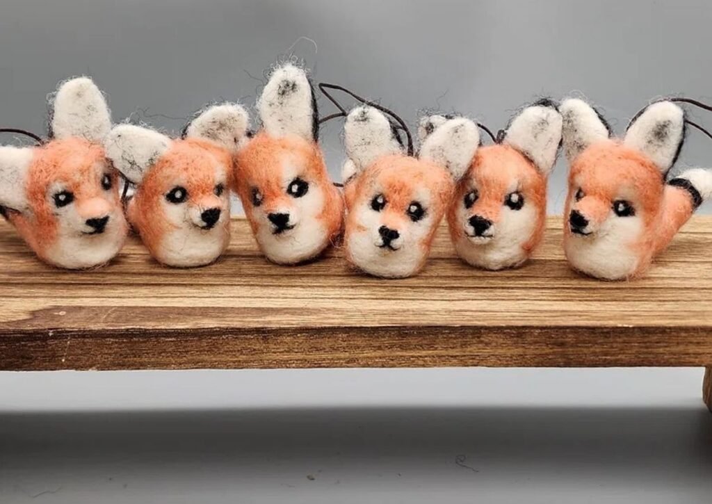 Handmade needle felted fox ornaments on wooden surface - Hillyarn custom wool design